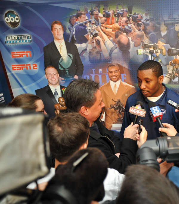 Members of the media interviewing a football player.
