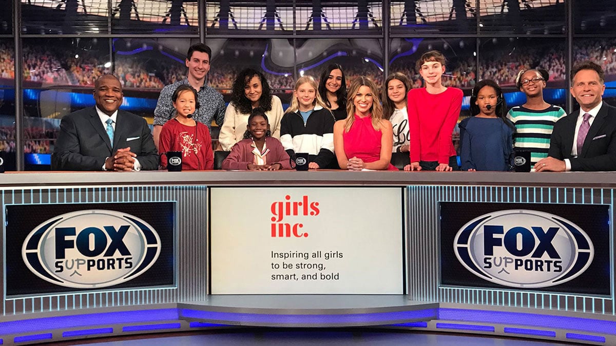 Penn State students and Alumni on set at Fox Sports with a bunch of young girls and a graphic that reads, Girls, Inc.: Inspiring all girls to be strong, smart, and bold