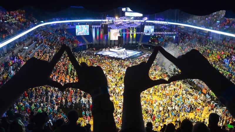 Two sets of hands for diamond shape silhouettes in front of a packed floor for THON at the Bryce Jordan Center.