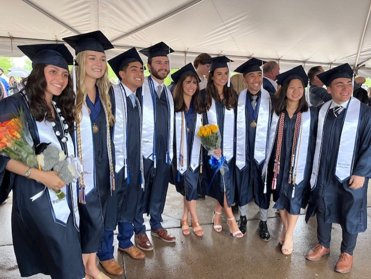 A line of students in blue caps and gowns at commencment.
