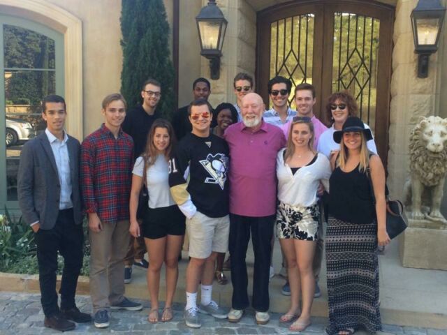 A group of a dozen students pose with Hollywood producer/director Don Bellisario and his wife Vivien