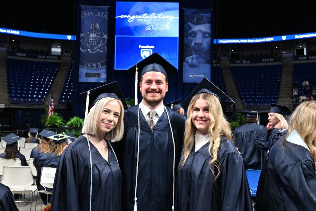 Three students in caps and gowns.