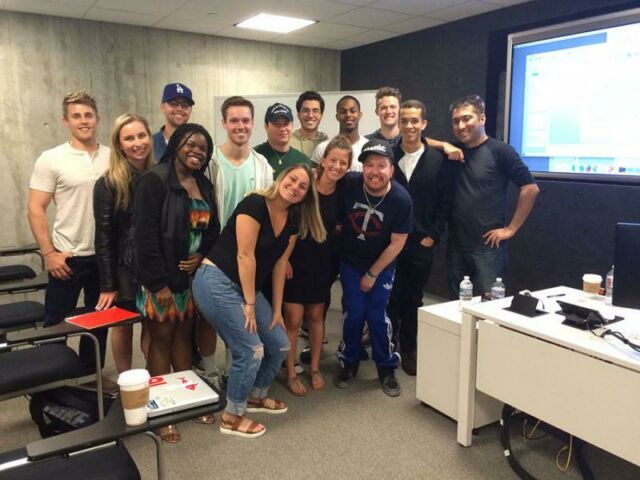 Thirteen students pose in a classroom setting with actor/comedian Nick Swardson