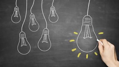 Chalk-drawn lightbulbs on a chalk board
